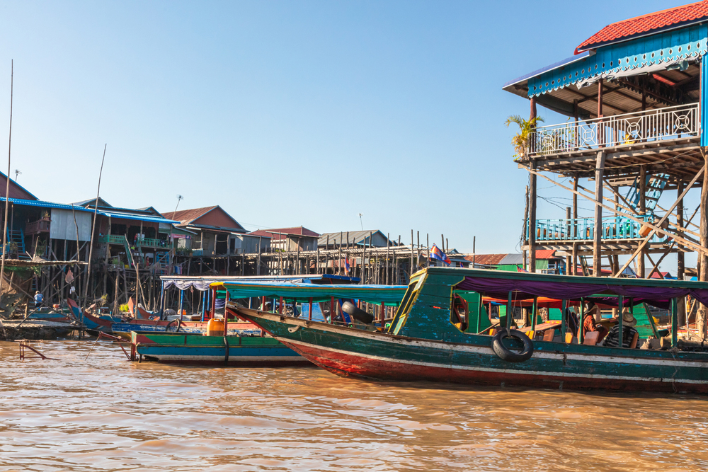 Kampong Phluk Floating Village on Tonle Sap lake near Angkor Wat, Siem Reap, Cambodia during sunset. The Stilt houses of the floating town. South East Asia. Boats cruising around and selling goods